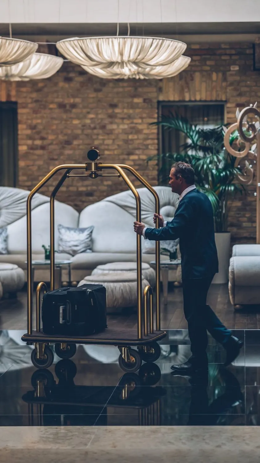A porter setting down luggage inside a designed room