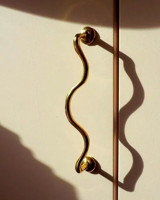 A brass door handle and the shadow it throws