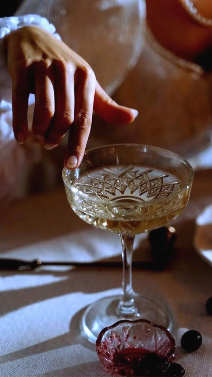 A coupe carried on a silver tray — the register held in one gesture