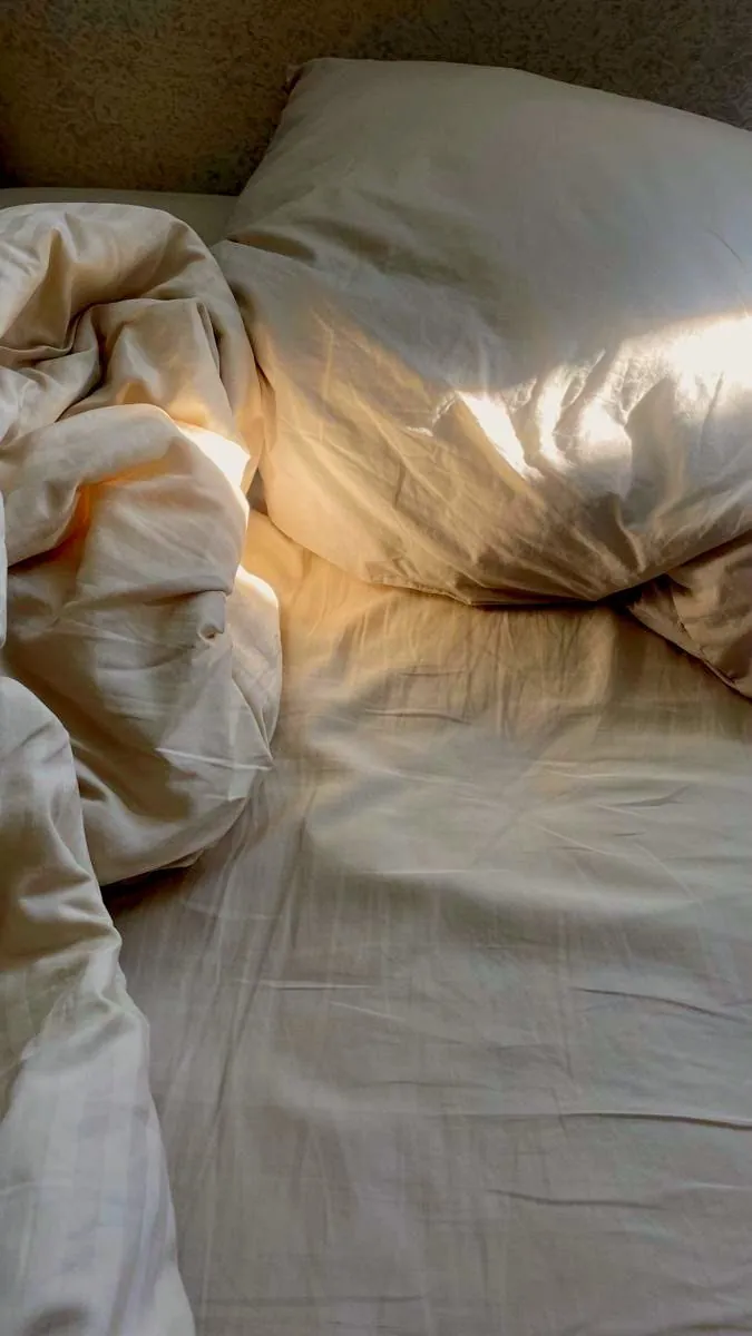 An unmade bed in morning light — what the guest left behind