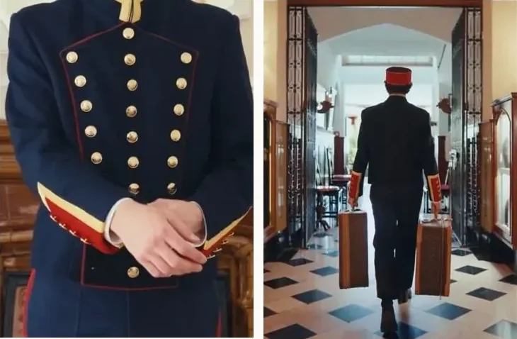A doorman's braided cuff and a bellhop carrying luggage across a checkered lobby
